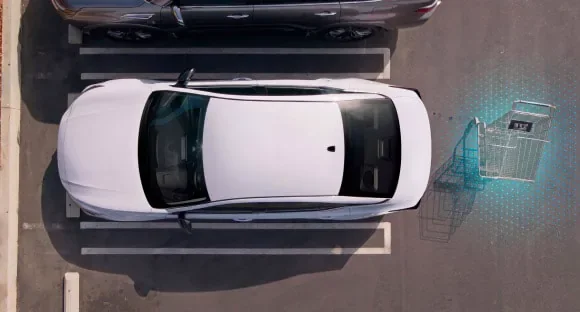 Top view of a white 2027 Nissan Altima in a parking lot with rear sensors detecting a shopping cart behind it at Orr Nissan of Shreveport in Shreveport LA